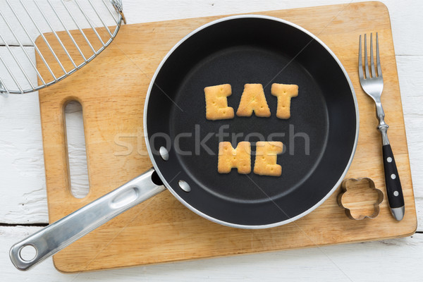 Letter biscuits word EAT ME and cooking equipments. Stock photo © vinnstock