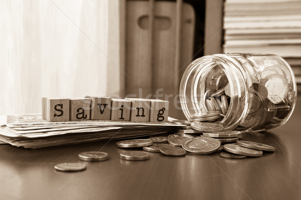 Money saving word with coins and banknotes, Sepia toned Stock photo © vinnstock