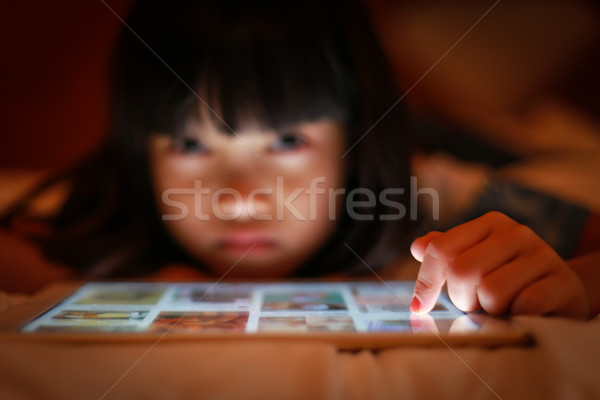 Asian kid using internet tablet screen. Stock photo © vinnstock