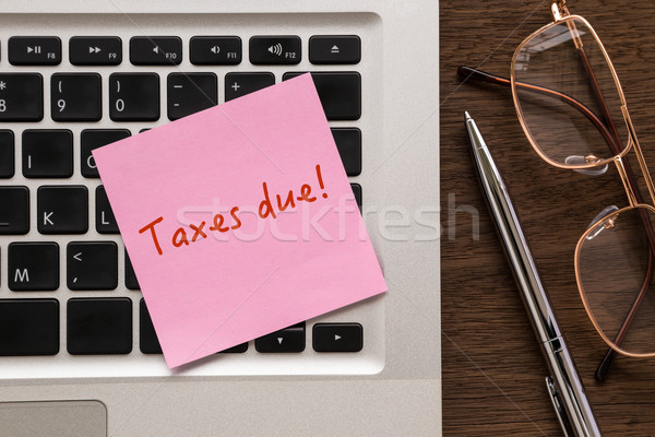 Notepad with word ' Taxes due ' putting on laptop  Stock photo © vinnstock