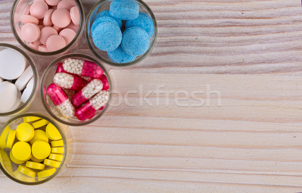 Various pills and capsules in glass containers top view Stock photo © viperfzk