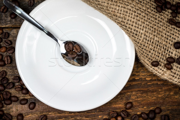 Coffee beans on spoon with white plate and surrounding coffeebea Stock photo © viperfzk