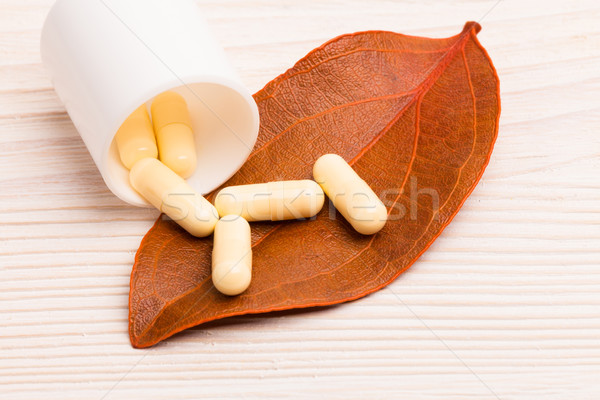 Medycyny alternatywnej pomarańczowy liści biały pojemnik drewniany stół Zdjęcia stock © viperfzk