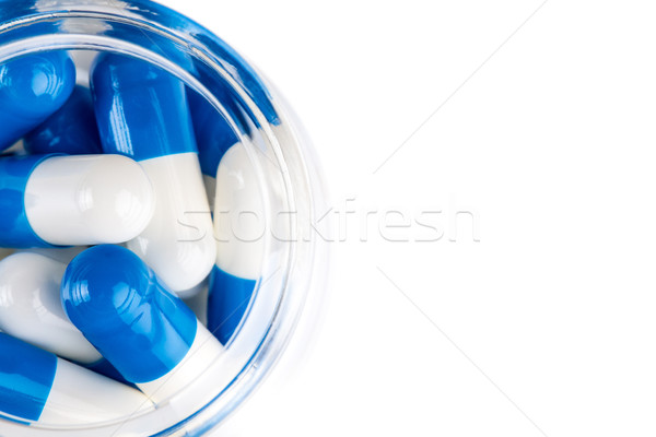 Blue white capsules in clear glass container top view Stock photo © viperfzk