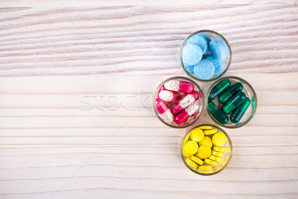 Pills and capsules in glass containers Stock photo © viperfzk