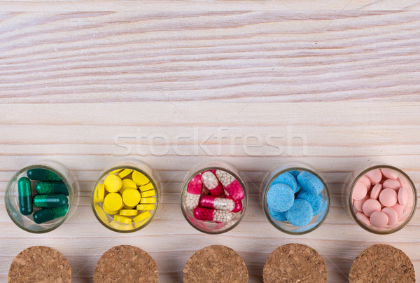 Various pills and capsules on light wooden table top view Stock photo © viperfzk