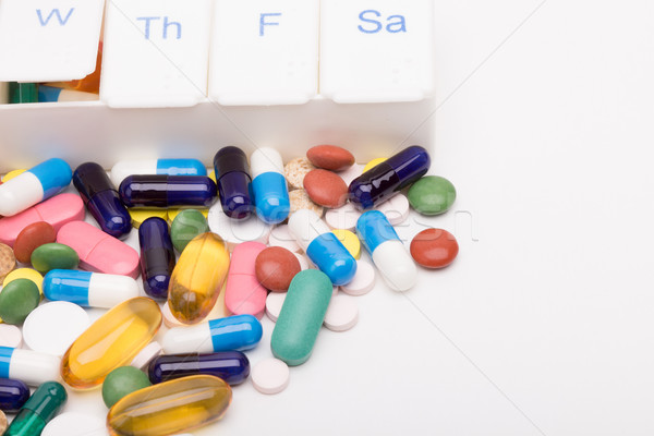 Color pills and capsules next to pill organizer  Stock photo © viperfzk