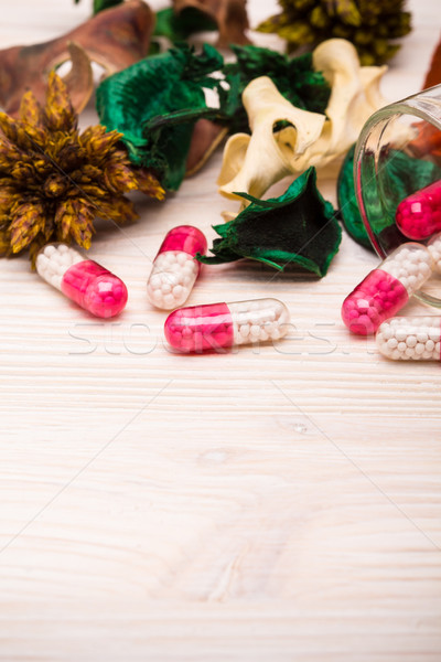 Pink capsules with green and orange leaves portrait Stock photo © viperfzk