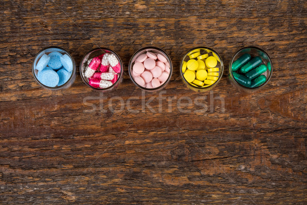 Various pills and capsules in glass containers Stock photo © viperfzk
