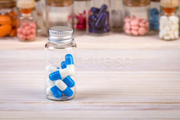 Blue white colored capsules in glass container Stock photo © viperfzk