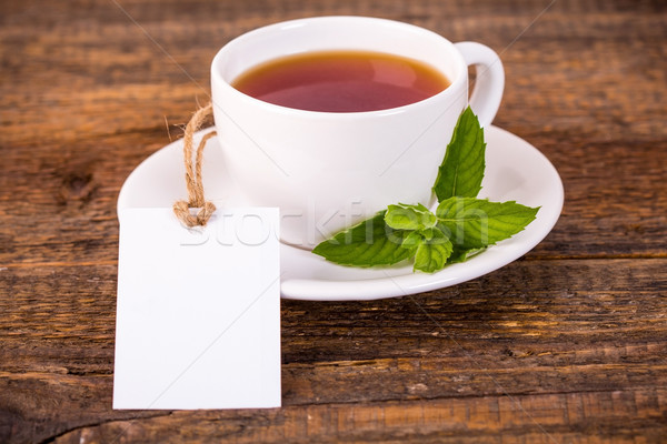 Cup of tea with green leaves and white tag Stock photo © viperfzk