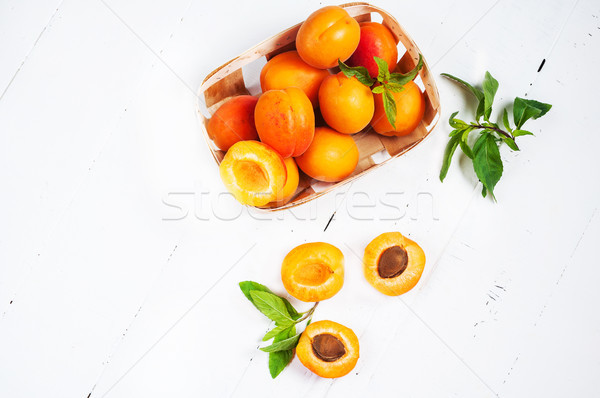 apricots in a basket on white wood background. top view Stock photo © voloshin311