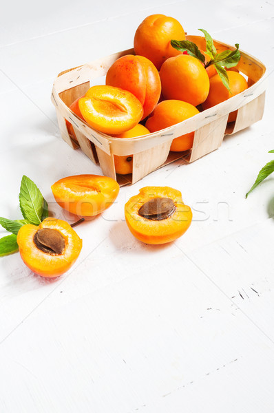 apricots in a basket on white wood background Stock photo © voloshin311