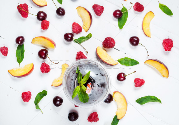 Various types of fruits with green leaves and frozen cocktail berries on white wood background Stock photo © voloshin311