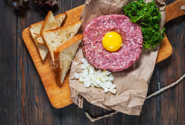 Beef tartare with bread and fresh onion on a wooden background Stock photo © voloshin311