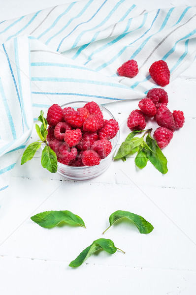 Stock photo: Ripe sweet raspberries in bowl on wooden table. Close up