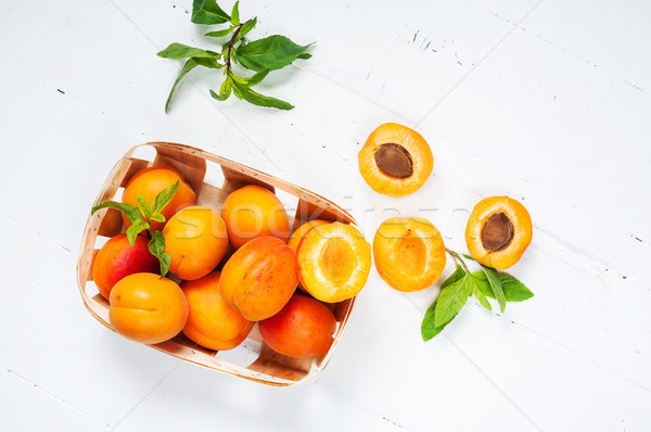 apricots in a basket on white wood background. top view Stock photo © voloshin311