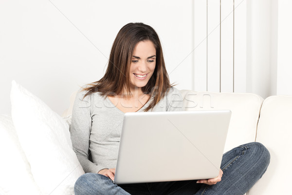 Bela mulher usando laptop sofá internet trabalhar rede Foto stock © vwalakte