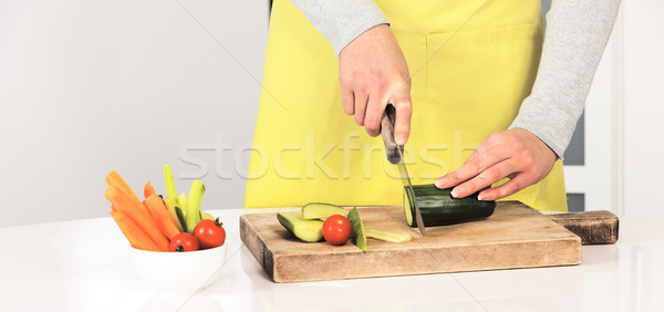 Woman cutting cucumber Stock photo © vwalakte