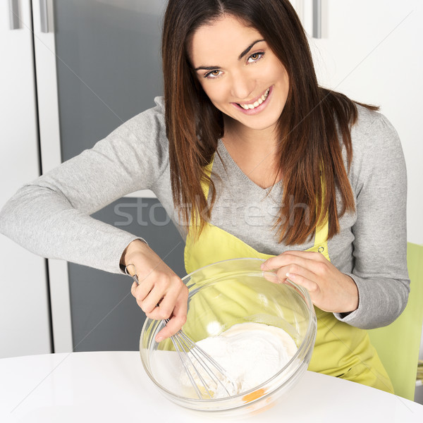 Beautiful woman whisking batter Stock photo © vwalakte