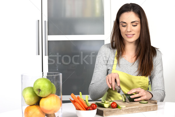 Woman cutting cucumber and vegetables Stock photo © vwalakte