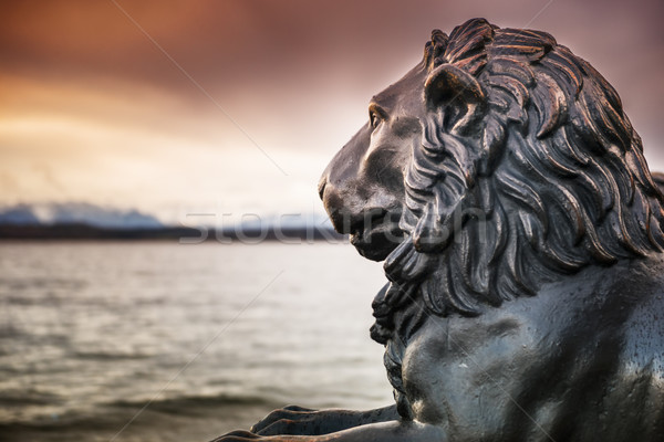 [[stock_photo]]: Lion · statue · lac · voir · nuages · montagne