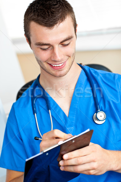 Carismático médico escrita clipboard branco estetoscópio Foto stock © wavebreak_media