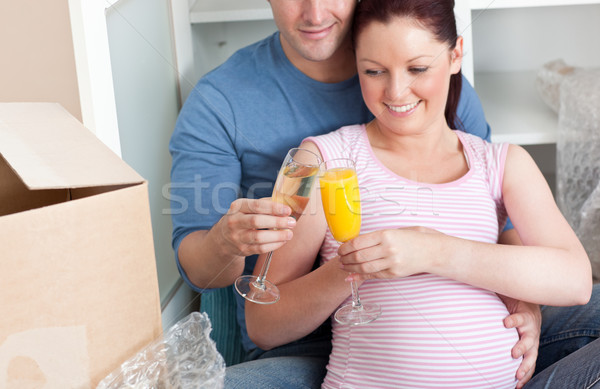 close-up of an adorable couple celebrating pregnancy and removal with champagne sitting on the floor Stock photo © wavebreak_media