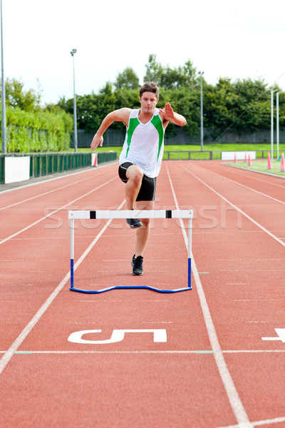 Sporty man jumping above hedge during a race in a stadium Stock photo © wavebreak_media