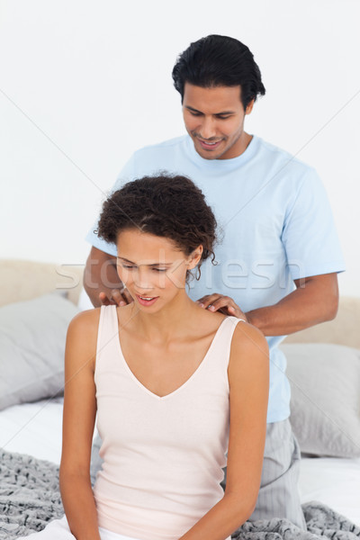 Attentive man doing a massage to his beautiful wife on their bed  Stock photo © wavebreak_media