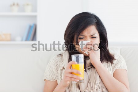 sad woman with orange juice on sofa in livingroom Stock photo © wavebreak_media