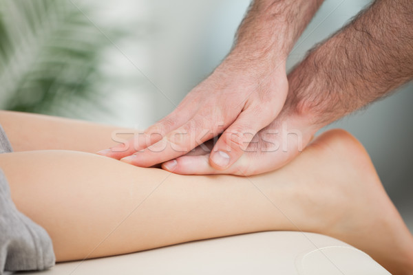 Physiotherapist massaging the calf of a woman in a room Stock photo © wavebreak_media