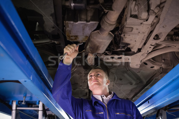 Concentré mécanicien au-dessous voiture garage [[stock_photo]] © wavebreak_media