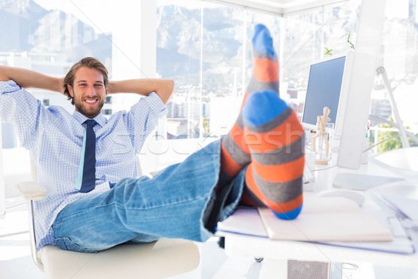 Designer relaxing at desk with no shoes and smiling Stock photo © wavebreak_media