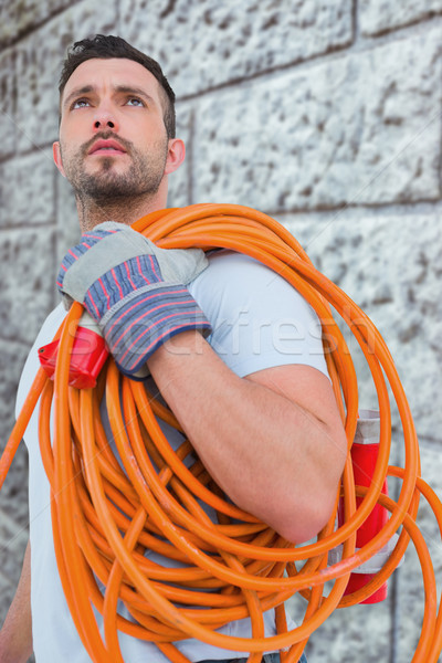 Composite image of repairman holding wire roll Stock photo © wavebreak_media