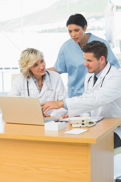 Doctors using laptop together at the medical office Stock photo © wavebreak_media