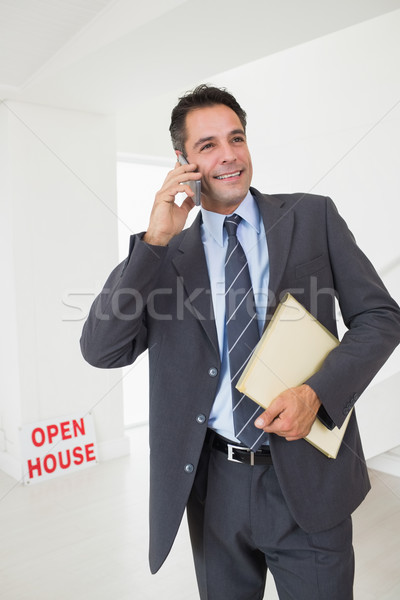 Real estate agent with documents using mobile phone Stock photo © wavebreak_media