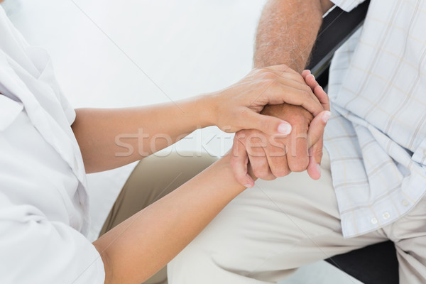 Mid section of a doctor holding patients hand Stock photo © wavebreak_media
