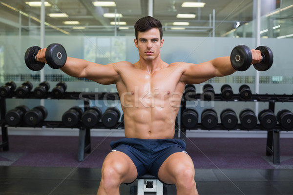 Muscular man exercising with dumbbells in gym Stock photo © wavebreak_media