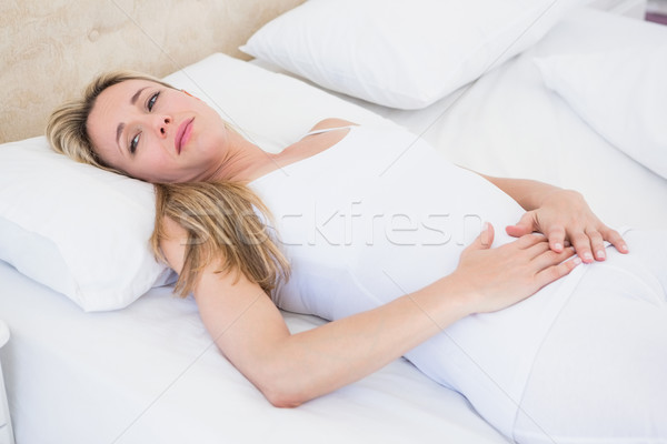 Grimacing woman suffering with stomach pain Stock photo © wavebreak_media