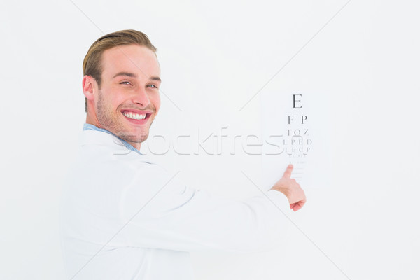 Stock photo: Smiling optician pointing eye test