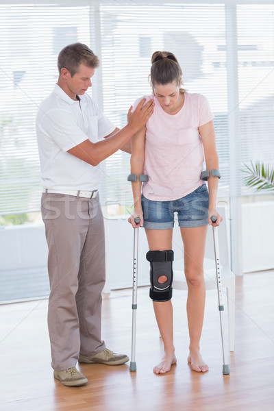 Doctor helping his patient walking with crutch Stock photo © wavebreak_media