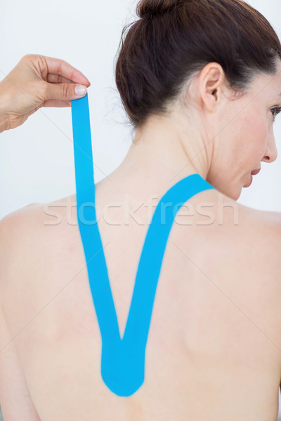 Physiotherapist applying blue kinesio tape to patients back  Stock photo © wavebreak_media