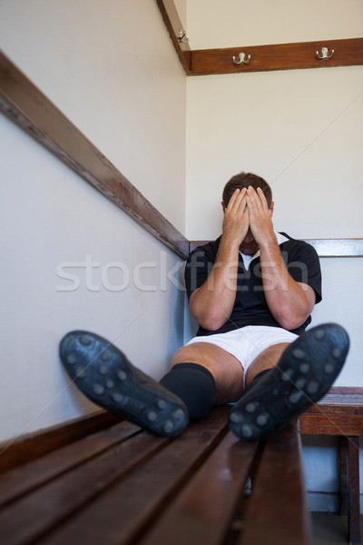 Tired rugby player covering face while sitting on bench Stock photo © wavebreak_media