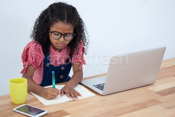 High angle view of businesswoman writing on book by laptop Stock photo © wavebreak_media