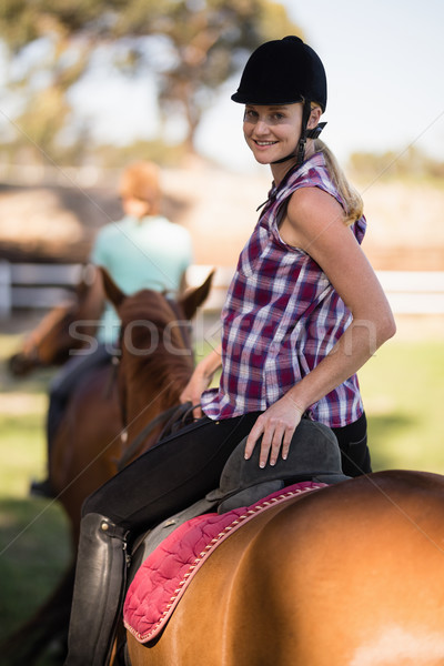 Portrait of woman horseback riding with friend sitting on horse in background Stock photo © wavebreak_media
