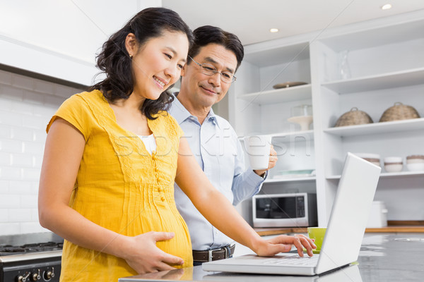 Boldog várandós pár laptopot használ konyha otthon Stock fotó © wavebreak_media