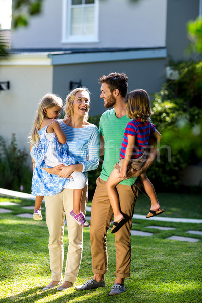 Stock photo: Parents carrying children in yard