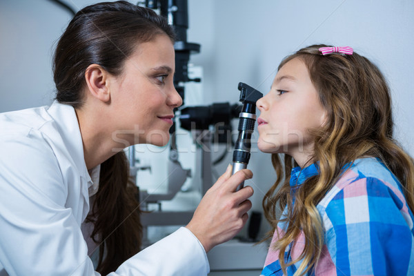 Female optometrist examining young patient with ophthalmoscope Stock photo © wavebreak_media