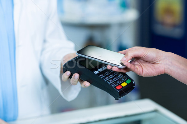 Woman paying bill through smartphone using NFC technology Stock photo © wavebreak_media